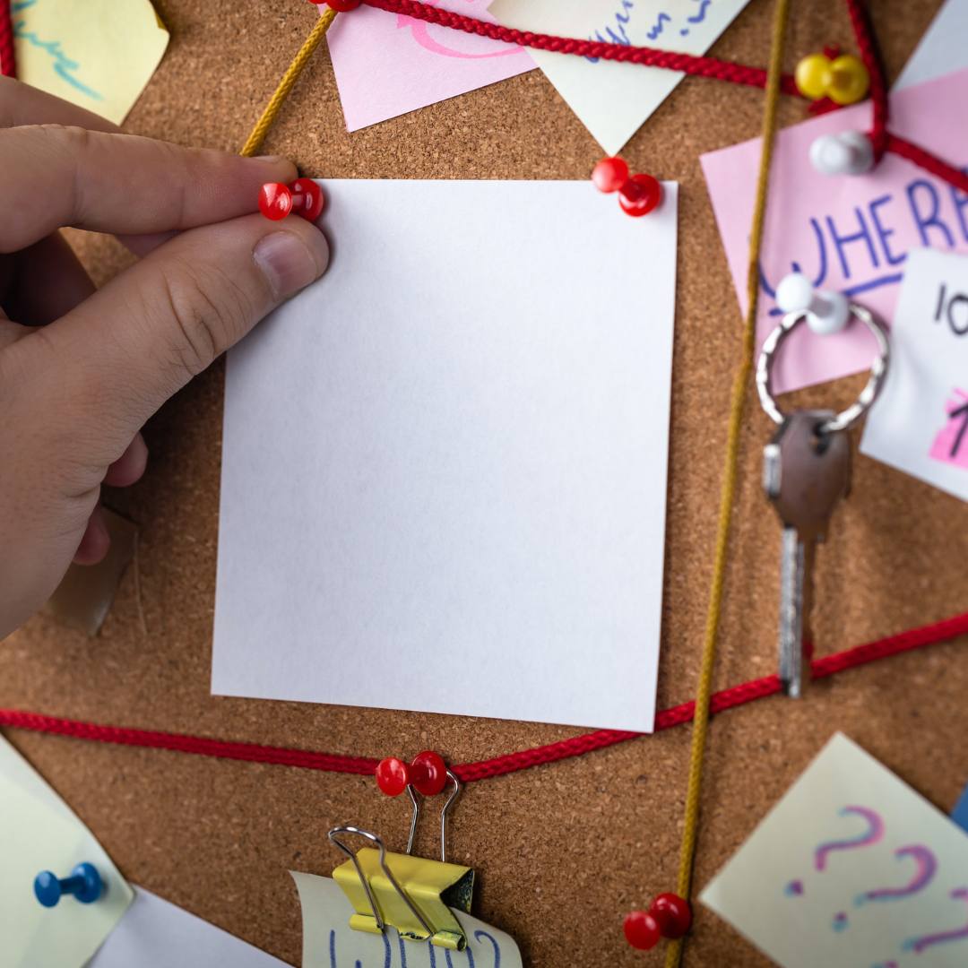 Note board with red string, red pins, keys and sticky notes